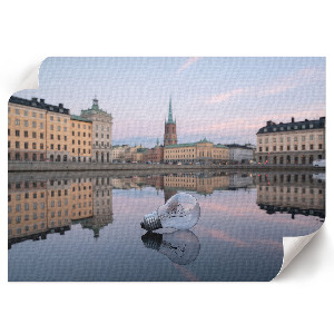 Plakat ścienny z motywem żarówki i panoramy miasta